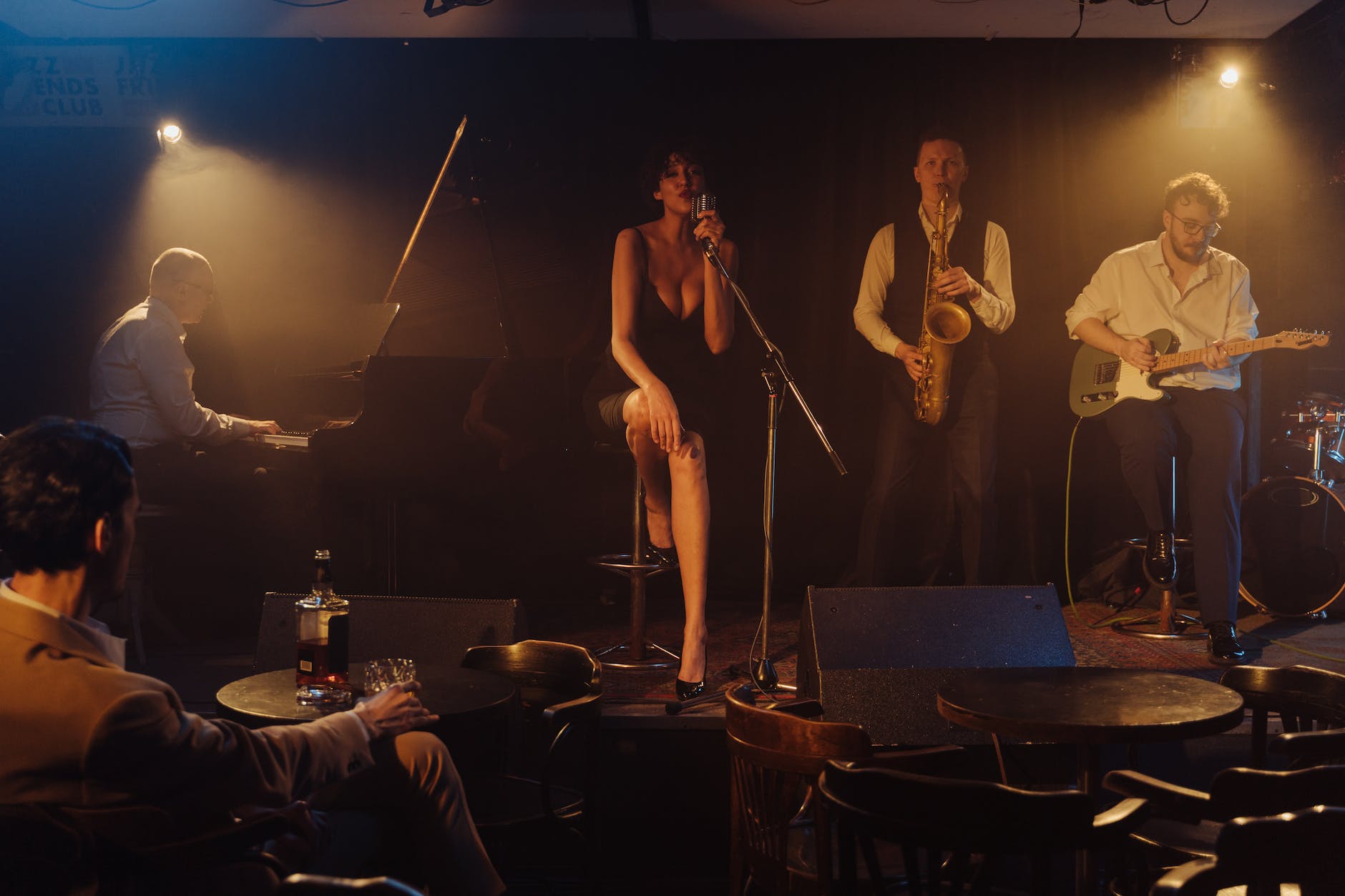 photo of a woman singing near musicians